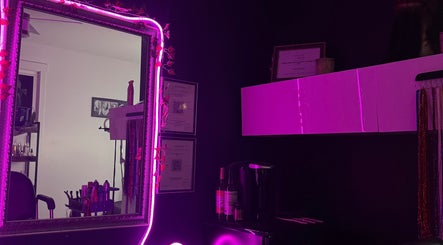 Stylish interior of NanoGlow Hair Co. salon, Fort Erie, Ontario, CA, featuring neon-lit mirror and decor.