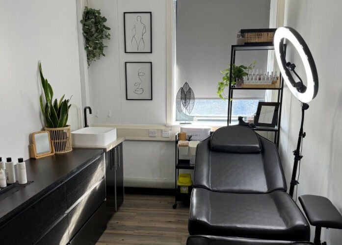 A serene treatment room at Muse Beauty + Wellness in Weymouth, England, GB, featuring a comfortable black chair.