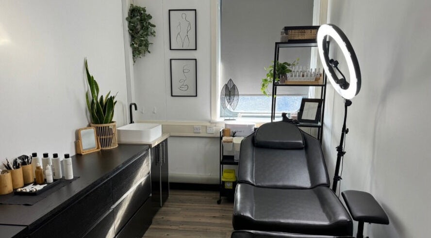 A serene treatment room at Muse Beauty + Wellness in Weymouth, England, GB, featuring a comfortable black chair.