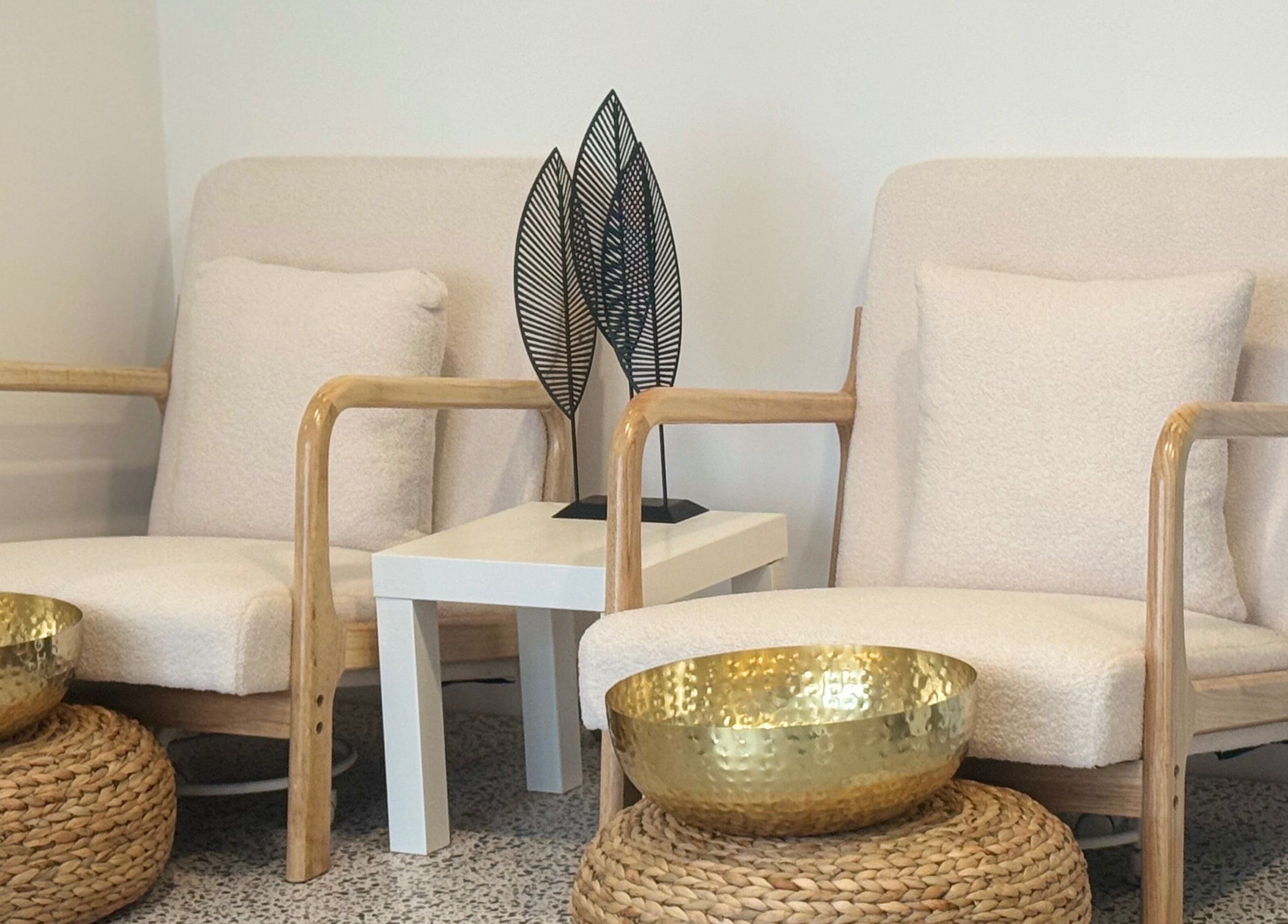 Elegant seating area at Muse Beauty + Wellness, Weymouth, England, GB with plush chairs and gold decor.