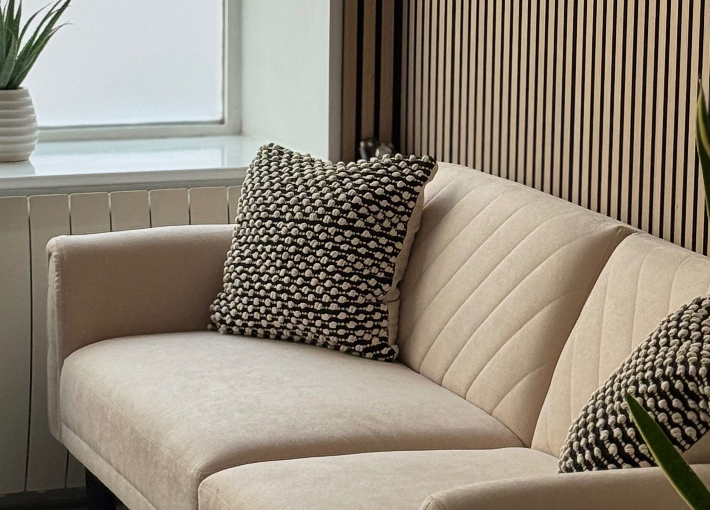 Elegant seating area at Muse Beauty + Wellness, Weymouth, England, GB, featuring a cozy sofa and decor.