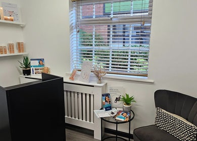 Cozy reception at DermaDivine Skin Rejuvenation, Tamworth, England, GB, featuring skincare displays and a plush chair.