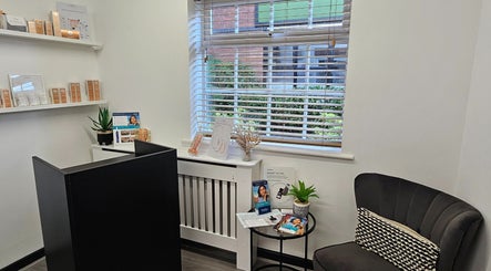 Cozy reception at DermaDivine Skin Rejuvenation, Tamworth, England, GB, featuring skincare displays and a plush chair.