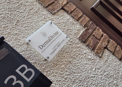 Exterior sign of DermaDivine Skin Rejuvenation, Tamworth, England, GB on a textured wall.