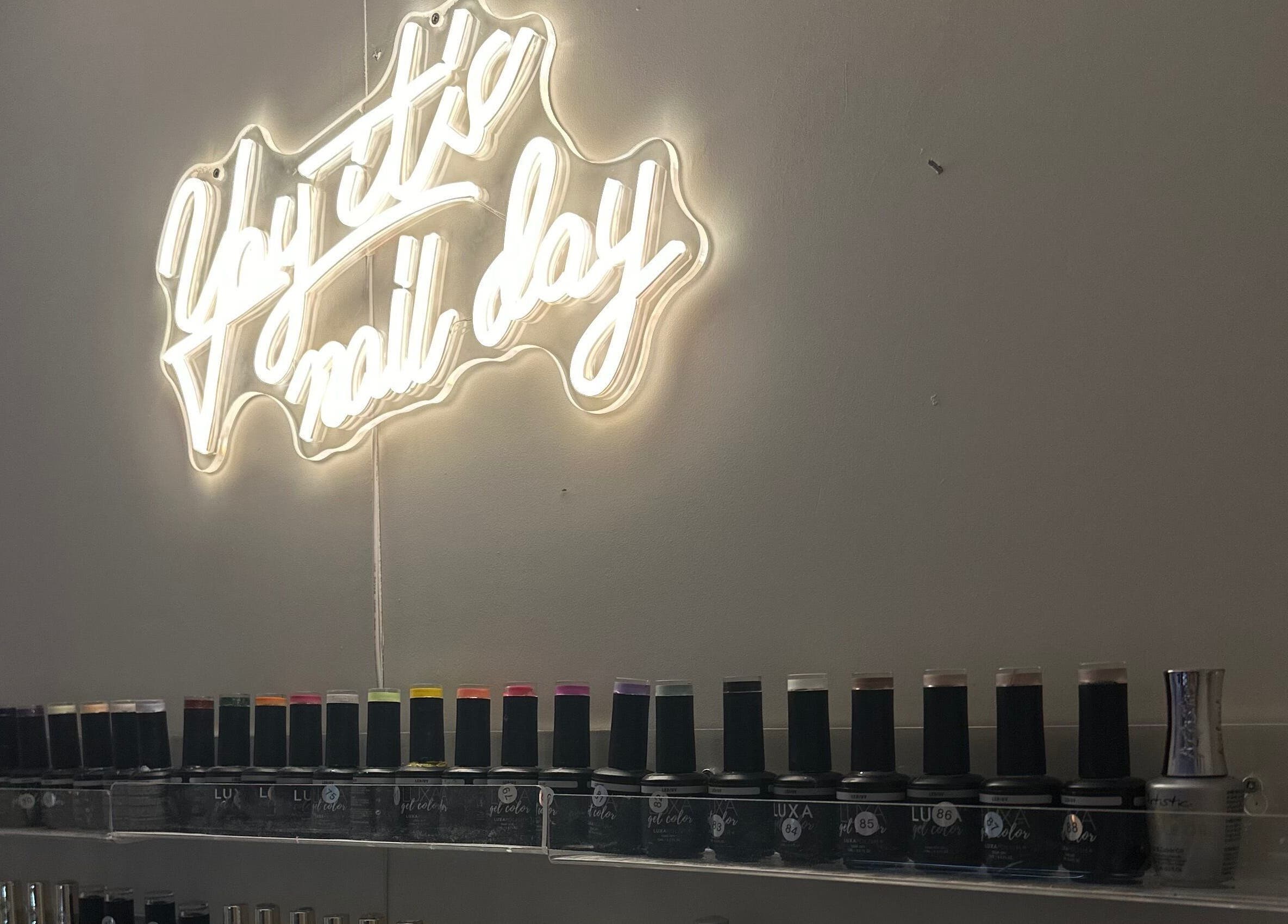 Neon sign 'yay it's nail day' and nail polish display at Milkshake Nails & Tan, Waitara, Taranaki, NZ.