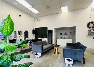 Modern interior of HR Hair Studio, Auckland, NZ, featuring chic furniture and lush plants.
