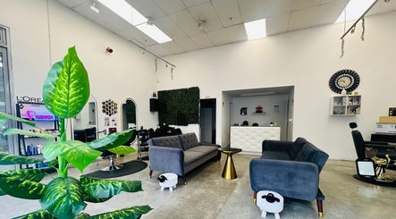 Modern interior of HR Hair Studio, Auckland, NZ, featuring chic furniture and lush plants.