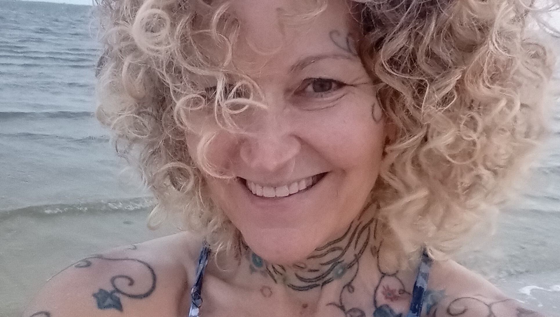 Smiling individual by the ocean, Ocean Springs. Kathryn Lane, NASM CPT, CNC, MWC venue.