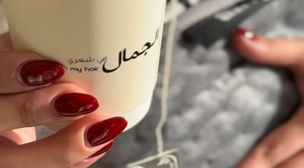 Close-up of manicured nails holding a branded cup at Beauty in my hair, Riyadh, Riyadh Province, SA.