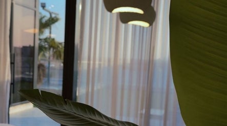 Serene interior of Beauty In My Hair, Riyadh, Riyadh Province, SA with leafy decor and soft lighting.