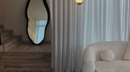 Chic interior of Beauty In My Hair in Riyadh, showcasing a plush sofa and artistic mirror.