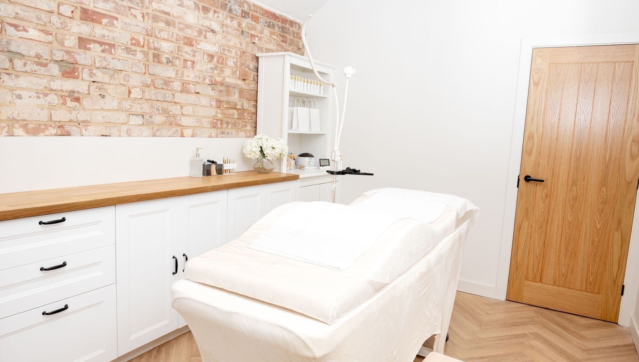Elegant treatment room at Naturalise Lash & Brow Studio in Addlestone, England, GB with white decor and cozy ambiance.