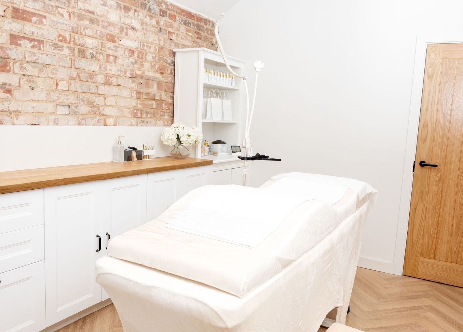 Elegant treatment room at Naturalise Lash & Brow Studio in Addlestone, England, GB with white decor and cozy ambiance.