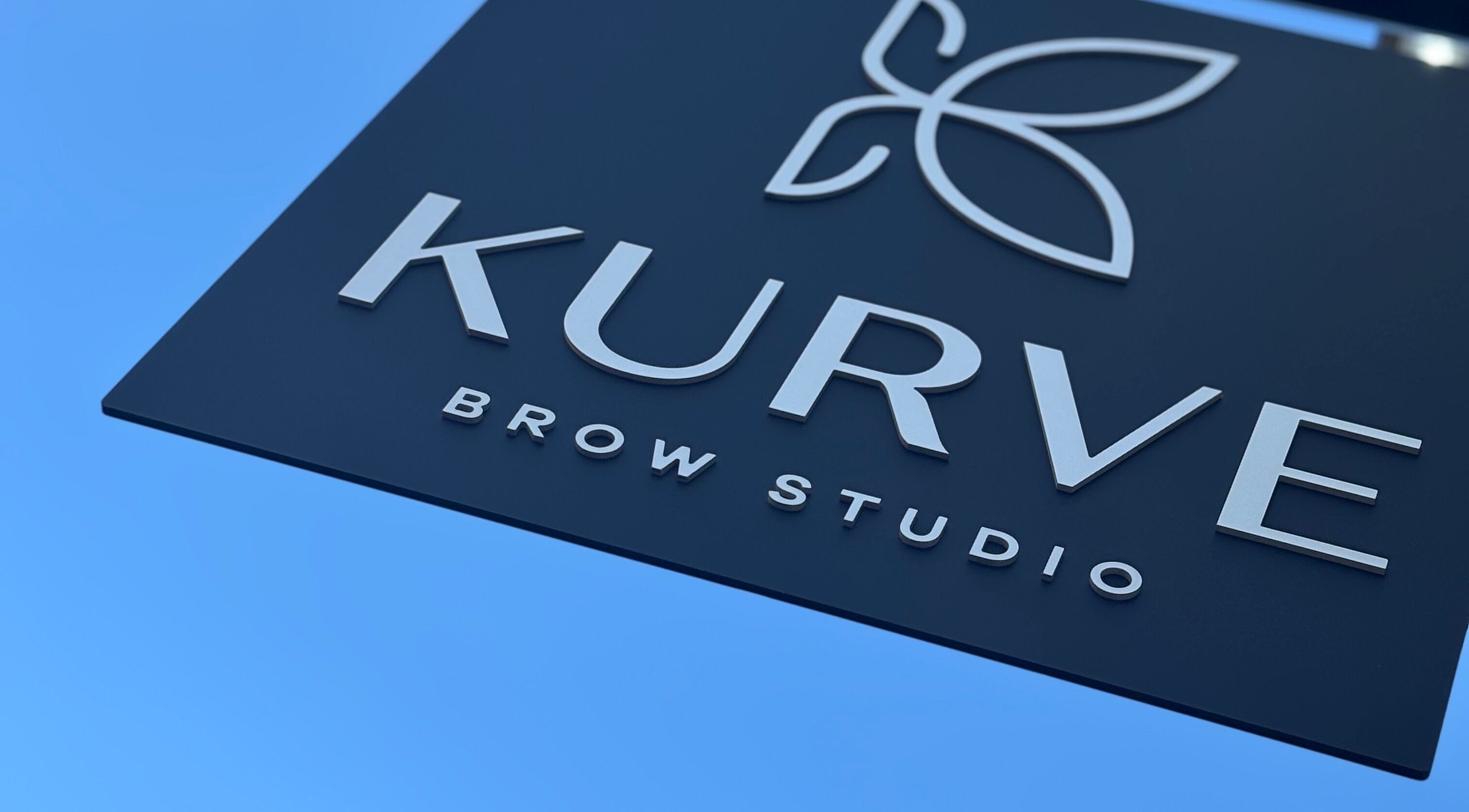 Keroline Carvalho's stylish Kurve Brow Studio sign in Sevenoaks, England, GB under clear sky.