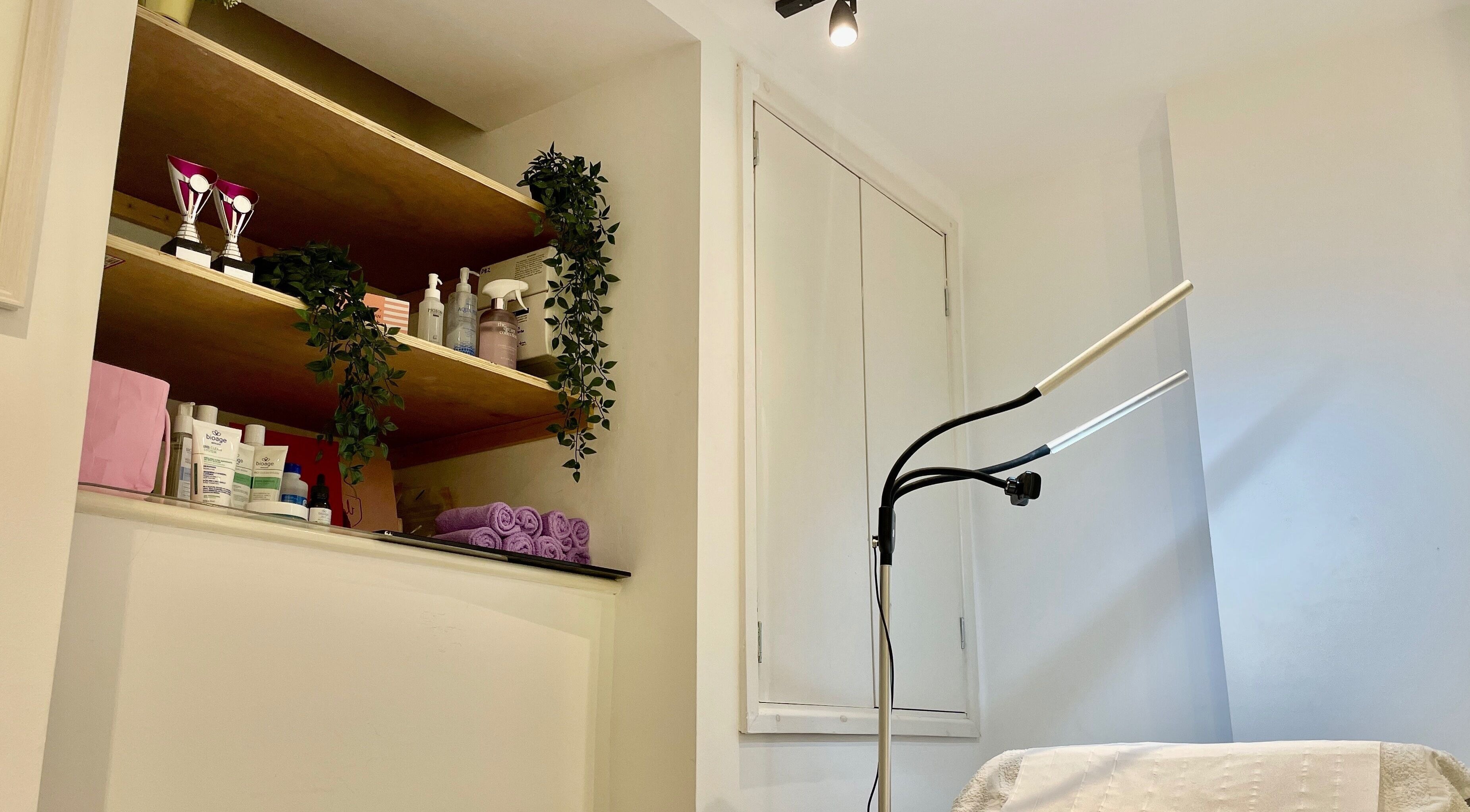 Modern treatment room at Koi Beauty Oxford, featuring shelves with products. Located in Oxford, England, GB.