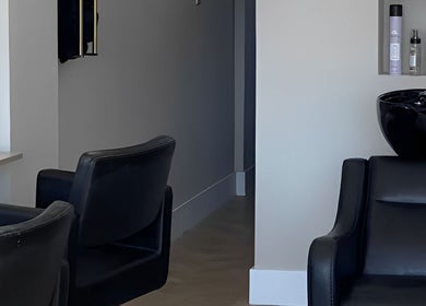 Elegant interior of Nevada Hair Studio in Edinburgh, Scotland, showcasing modern salon chairs and sleek hair products.