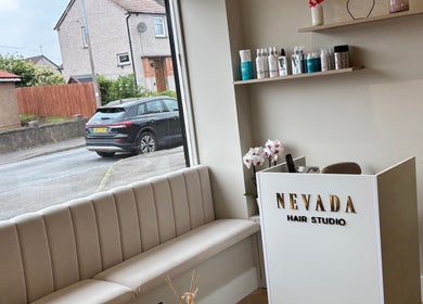 Elegant reception inside Nevada Hair Studio, Edinburgh, Scotland, GB with plush seating and stylish decor.