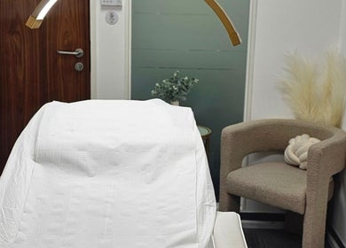 Relaxing treatment room at Diamond Luxe Aesthetics in Uxbridge, England, GB with cozy chair and dim lighting.