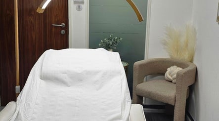 Cozy treatment room at Diamond Luxe Aesthetics in Uxbridge, England, GB with a plush chair and modern decor.