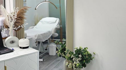 Elegant treatment room at Diamond Luxe Aesthetics, Uxbridge, England, GB with calming decor and white bed.