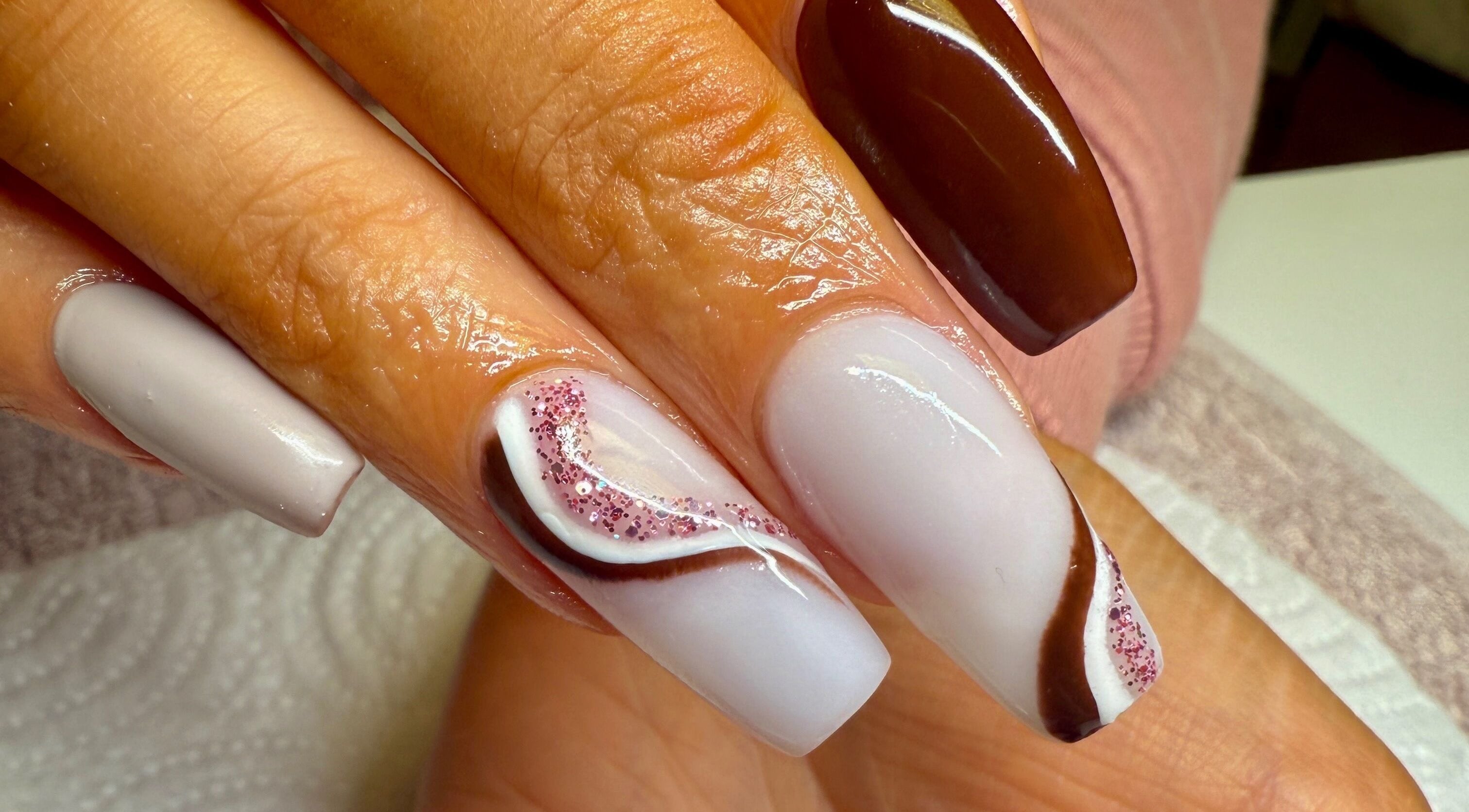 Stylish nail art at pnail_studio, Balbriggan, County Dublin, IE showcasing brown and white design with glitter.