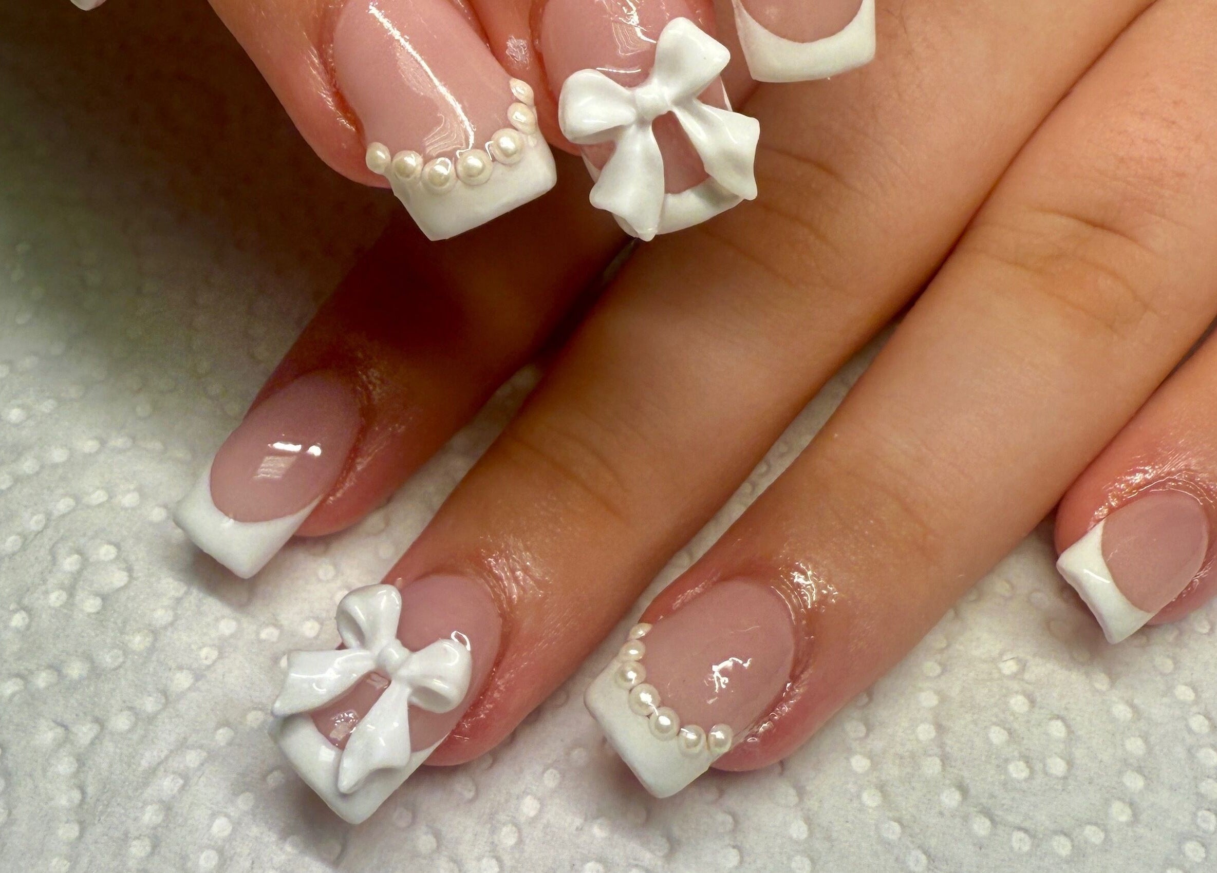 Elegant French tip nails with bows at pnail_studio, Balbriggan, County Dublin, IE.
