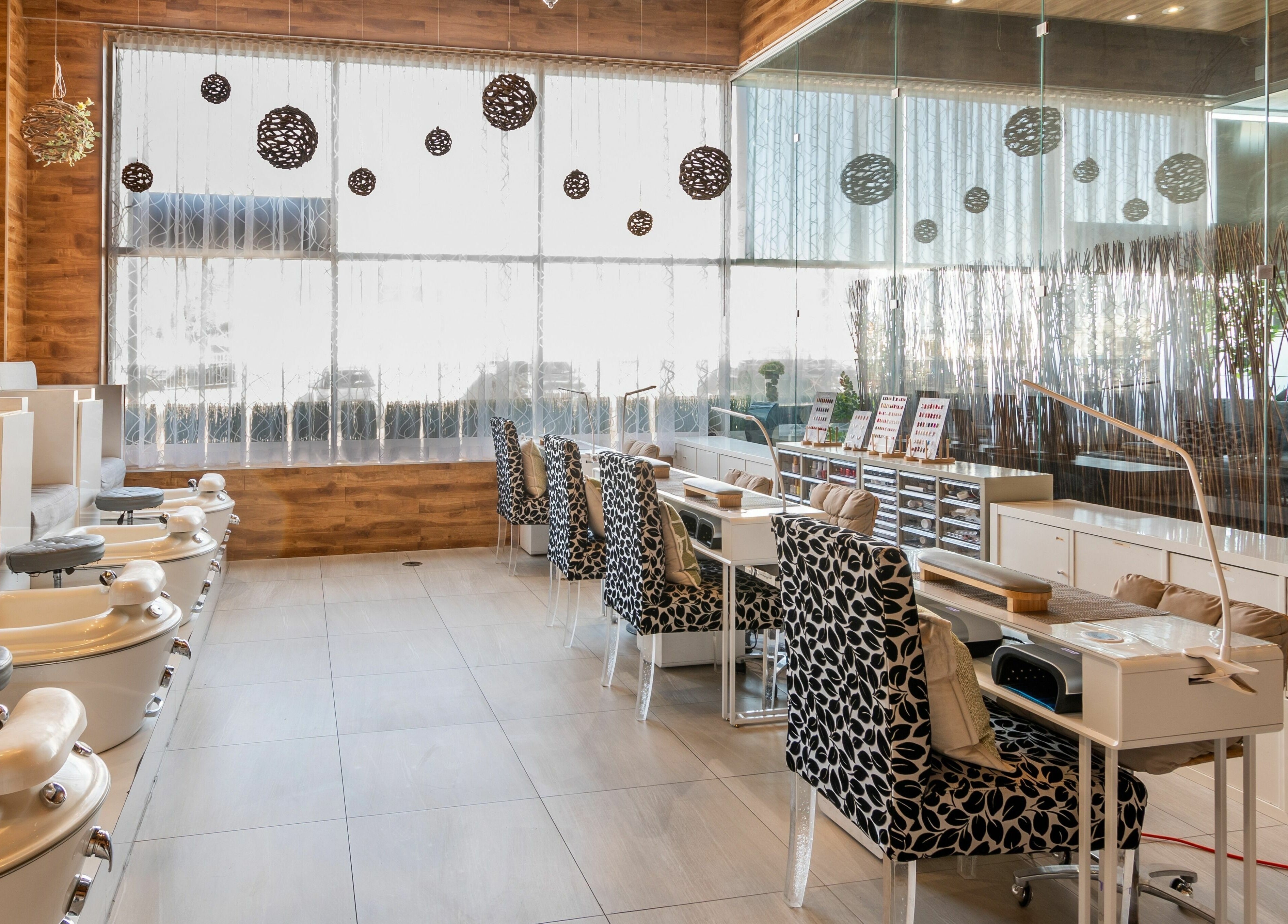 Elegant nail salon seating area at Aroma Day Spa in Markham, Ontario, CA, showcasing plush chairs and nail stations.