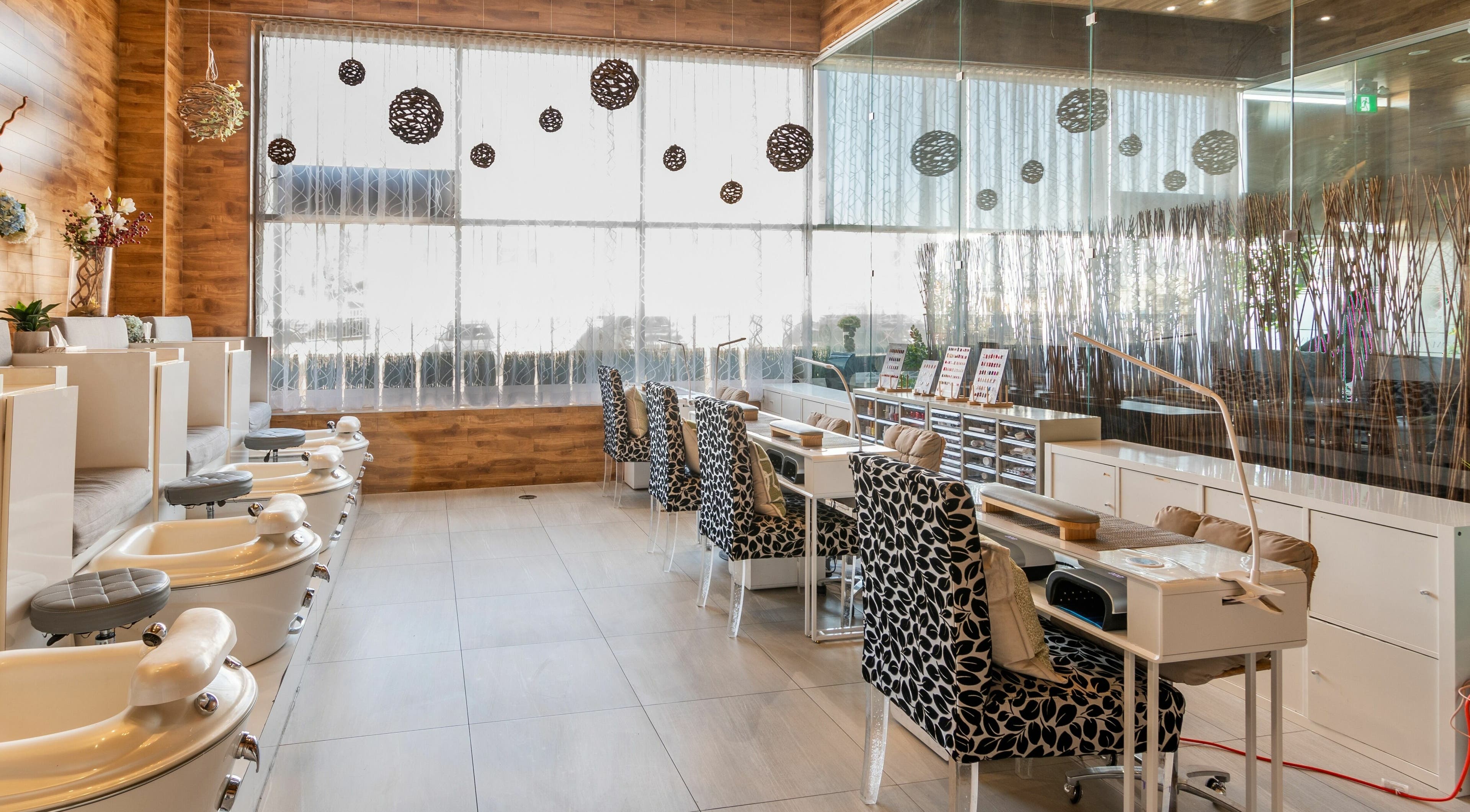 Elegant nail salon seating area at Aroma Day Spa in Markham, Ontario, CA, showcasing plush chairs and nail stations.