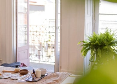 Sala iluminada do Hortus Studio yoga e terapias by Yayá Freitas em Porto, Porto, PT, com planta verde e utensílios de terapia.