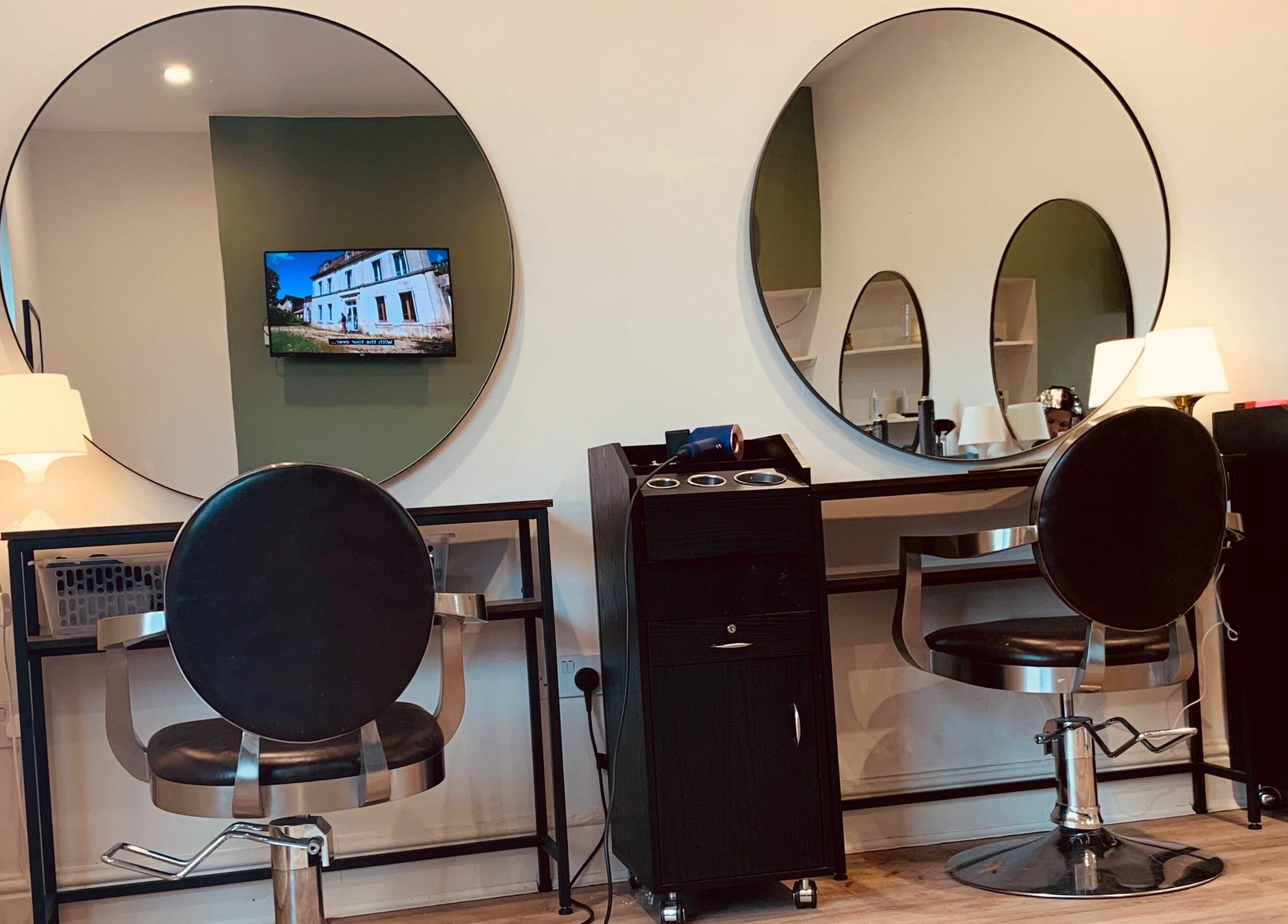 Chic styling stations at Dandy Hair in Hull, England, GB with round mirrors and modern chairs.