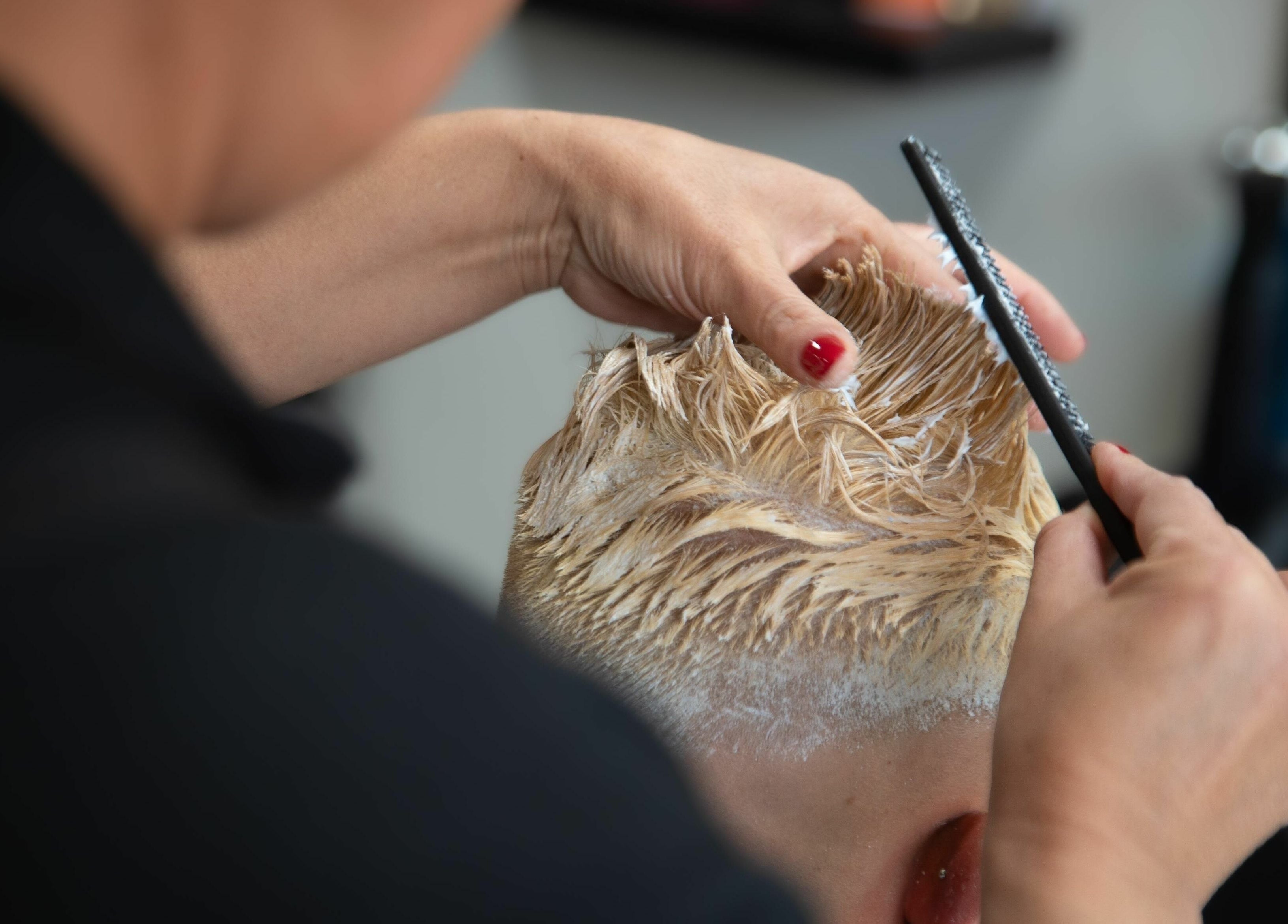 Hair stylist expertly applying color at Mkh Beauty House, Johannesburg, Gauteng, ZA.