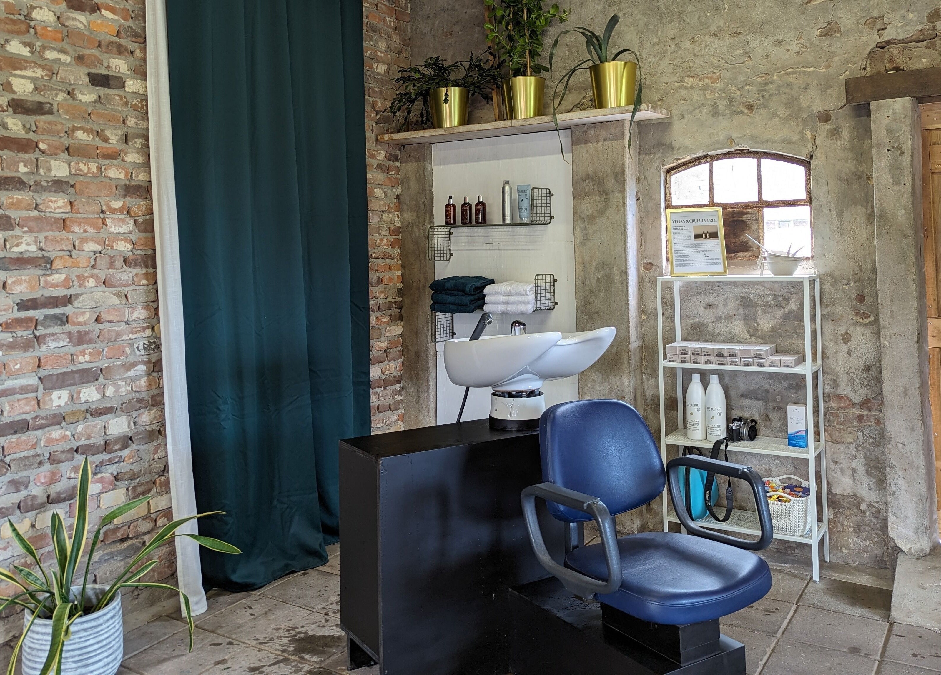 Shampoo-station bij Mina Haarsalon in Vroomshoop, Overijssel, NL met industriële bakstenen muur.