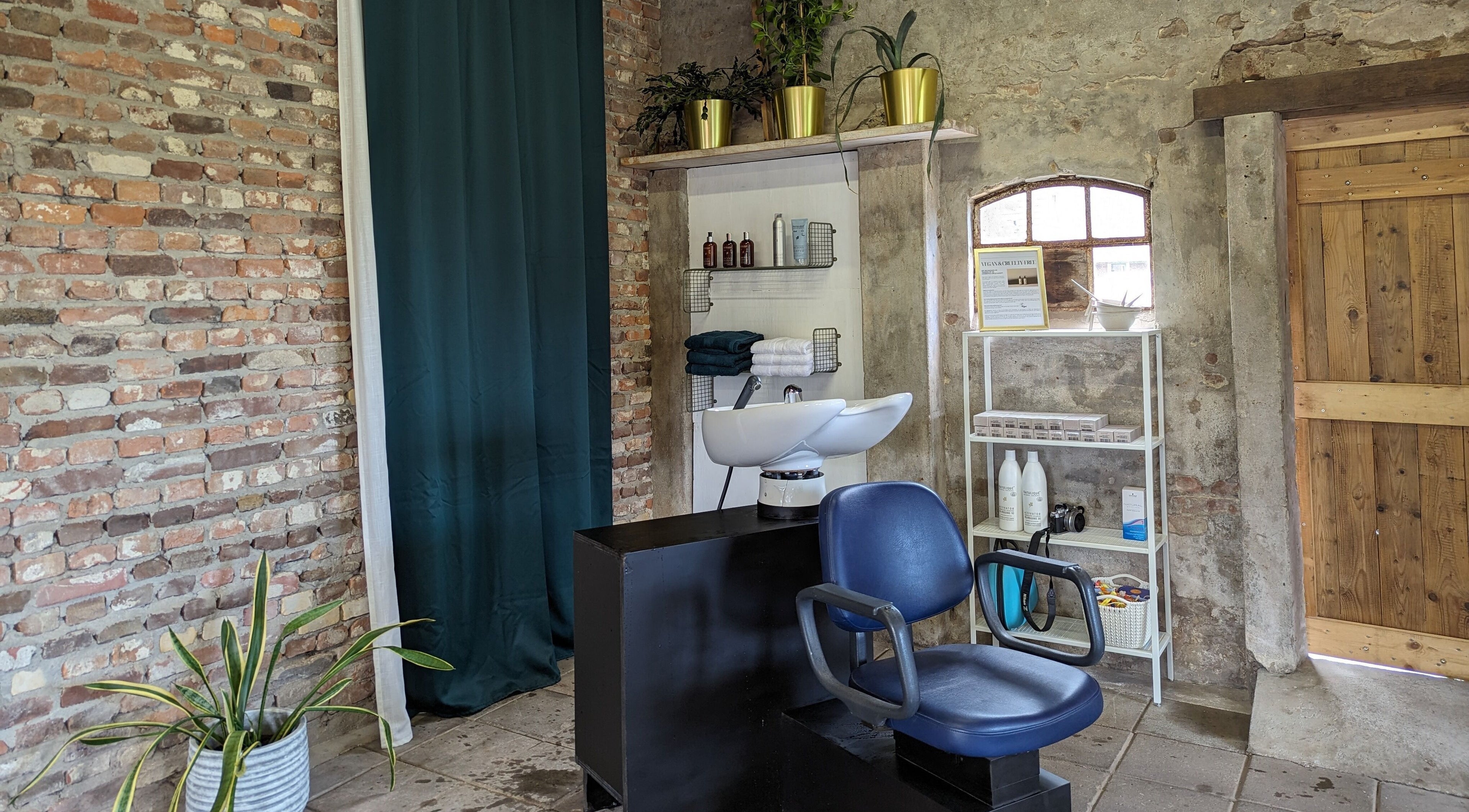 Shampoo-station bij Mina Haarsalon in Vroomshoop, Overijssel, NL met industriële bakstenen muur.