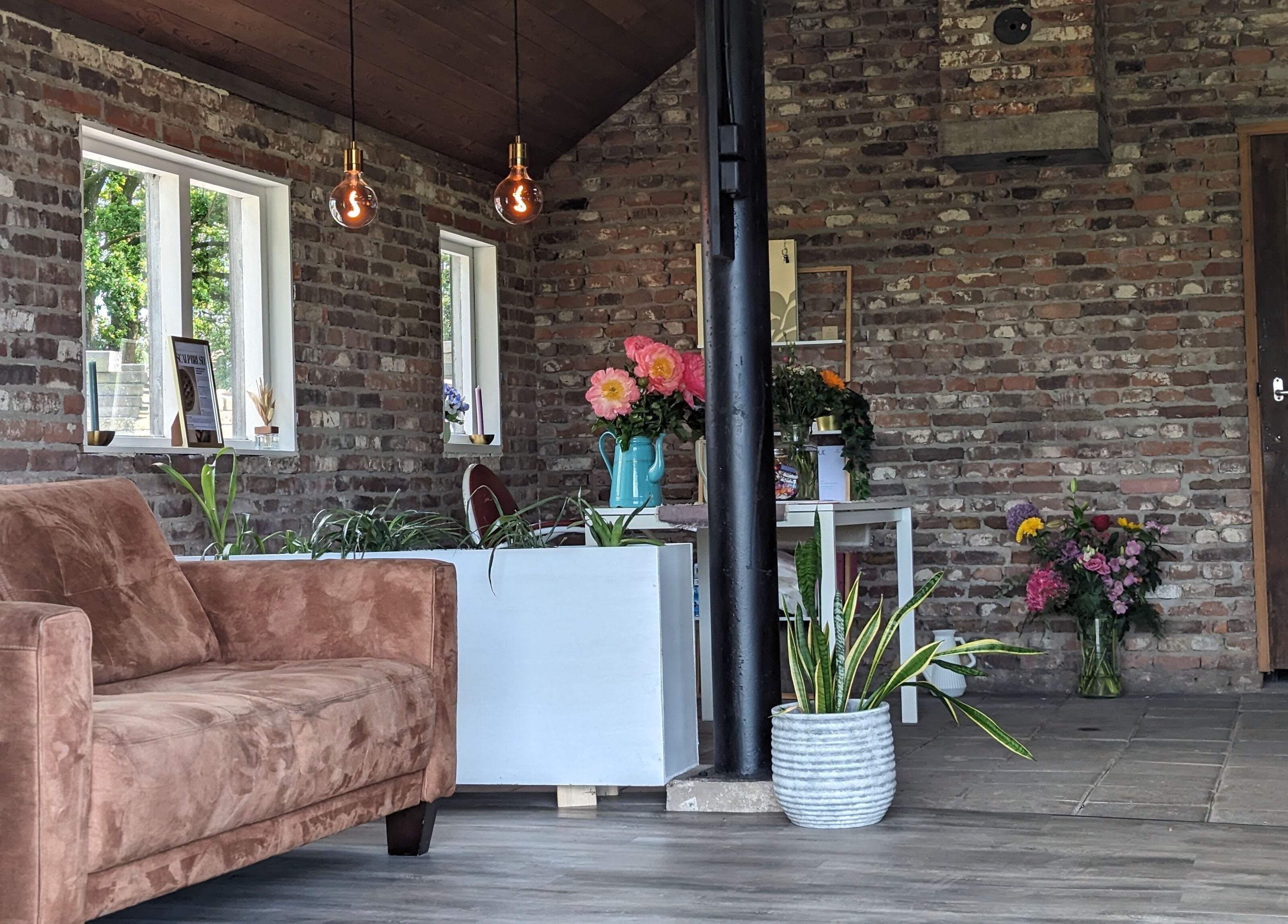 Gezellige lounge bij Mina Haarsalon, Vroomshoop, Overijssel, NL, met bloemen en natuurlijke elementen.