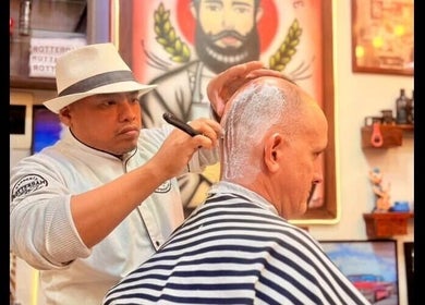 Barbero profesional en Barberia Rotterdam, Miraflores, Provincia De Lima, PE realizando corte de cabello afeitado.