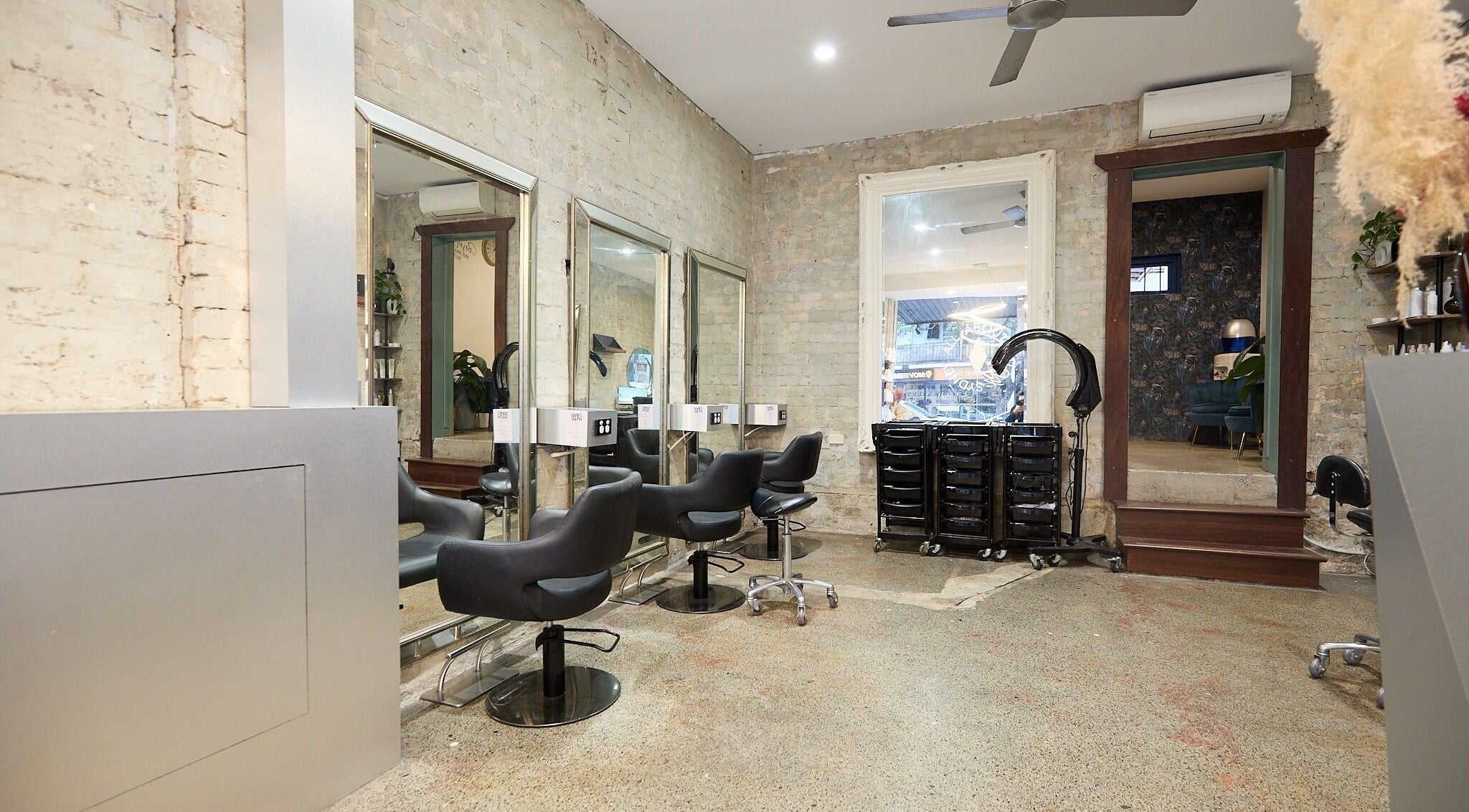 Stylish interior of All About Salon in Surry Hills, New South Wales, featuring sleek chairs and mirrors.
