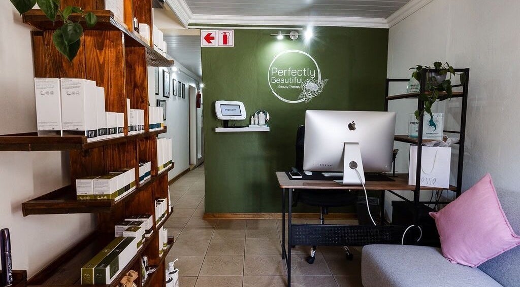 Welcoming lobby of Perfectly Beautiful in Bloemfontein, Free State, ZA with computer and display shelves.