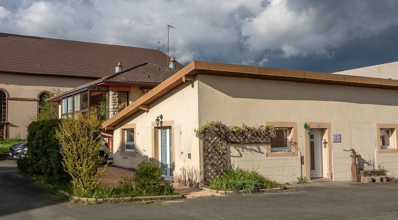 Extérieur de Les Mains De Matthieu à Bessoncourt, Bourgogne-franche-comté, FR, entouré de verdure.