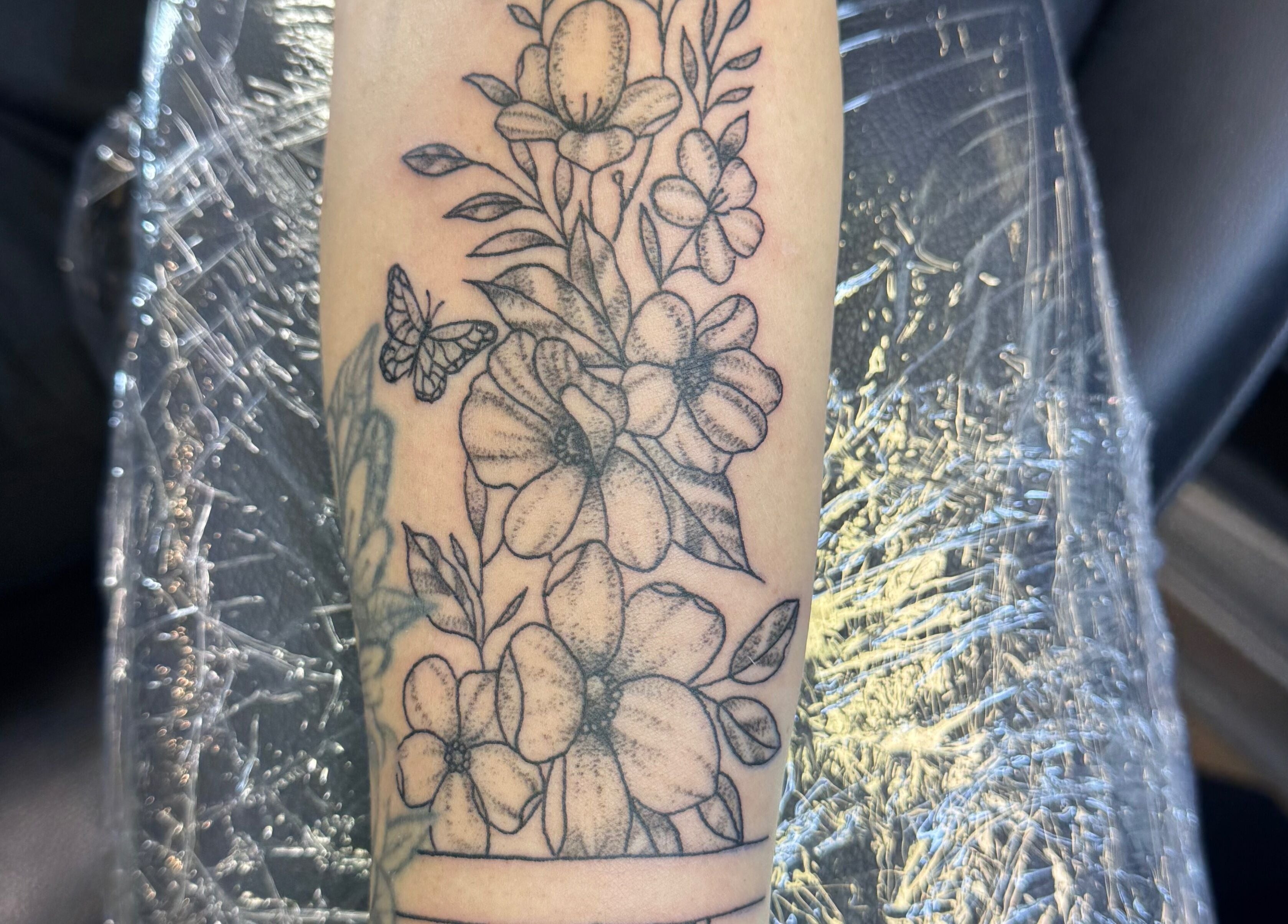 Detailed floral tattoo on arm, designed at Asatru Tattoos, Cardiff, Wales, GB.