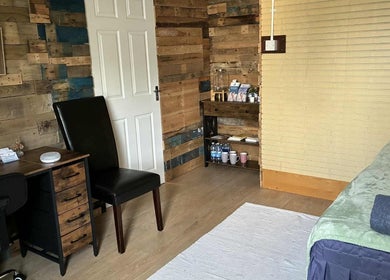Cozy therapy room at Jane Sandford Hypnotherapy and Holistic Health, Liskeard, England, GB with a wooden desk.