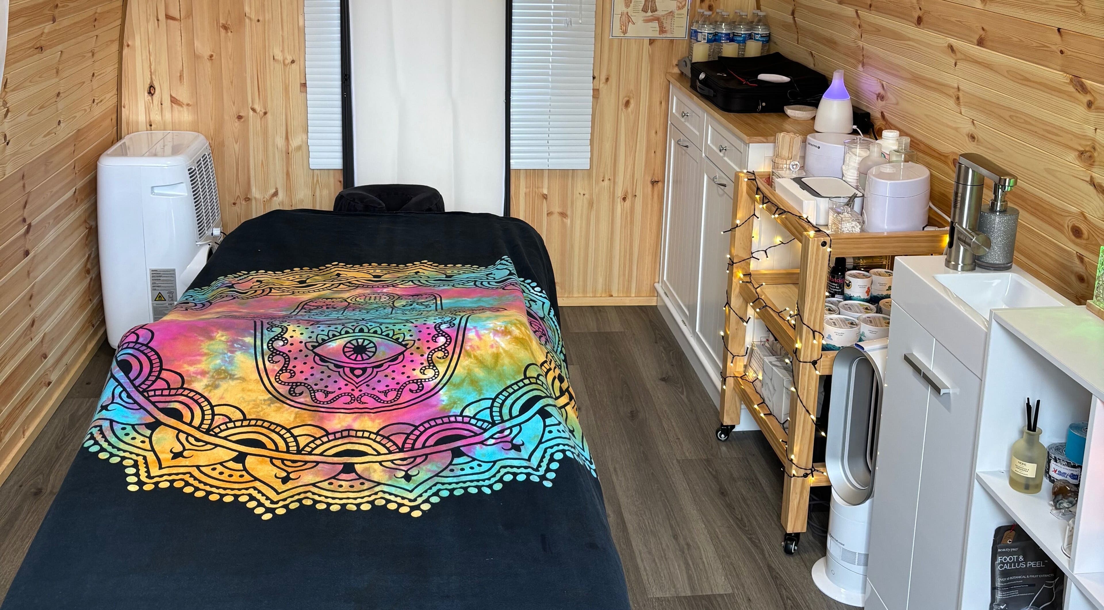 Relaxing massage room at Dragonfly Beauty & Lotus Massage Therapy, Timsbury, England with vibrant decor.