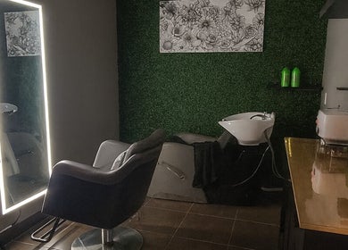Elegant salon station at Chemically Dependent in Chandler, Arizona, US featuring a modern chair and illuminated mirror.