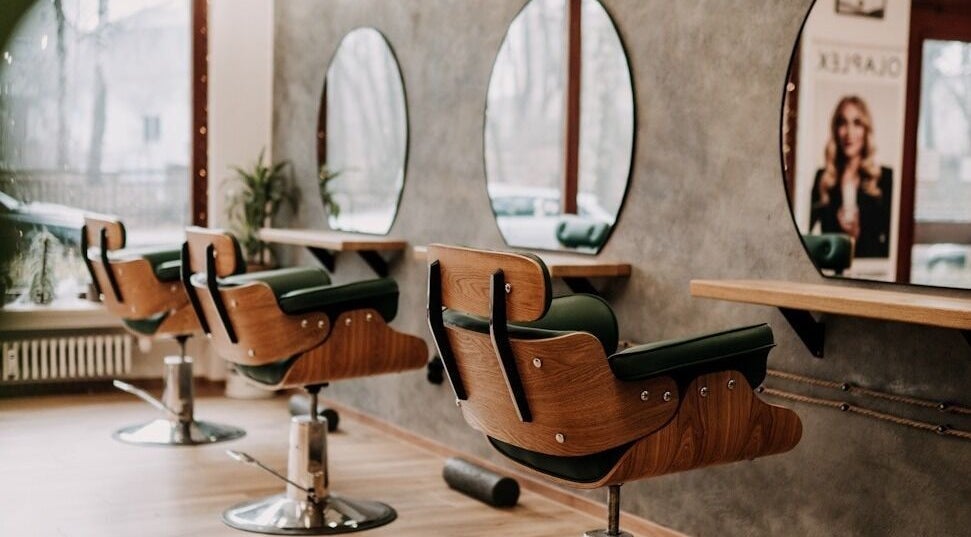 Moderne Friseurstühle in CutArtTique, Dachau, Bayern, DE vor stilvollen Spiegeln.