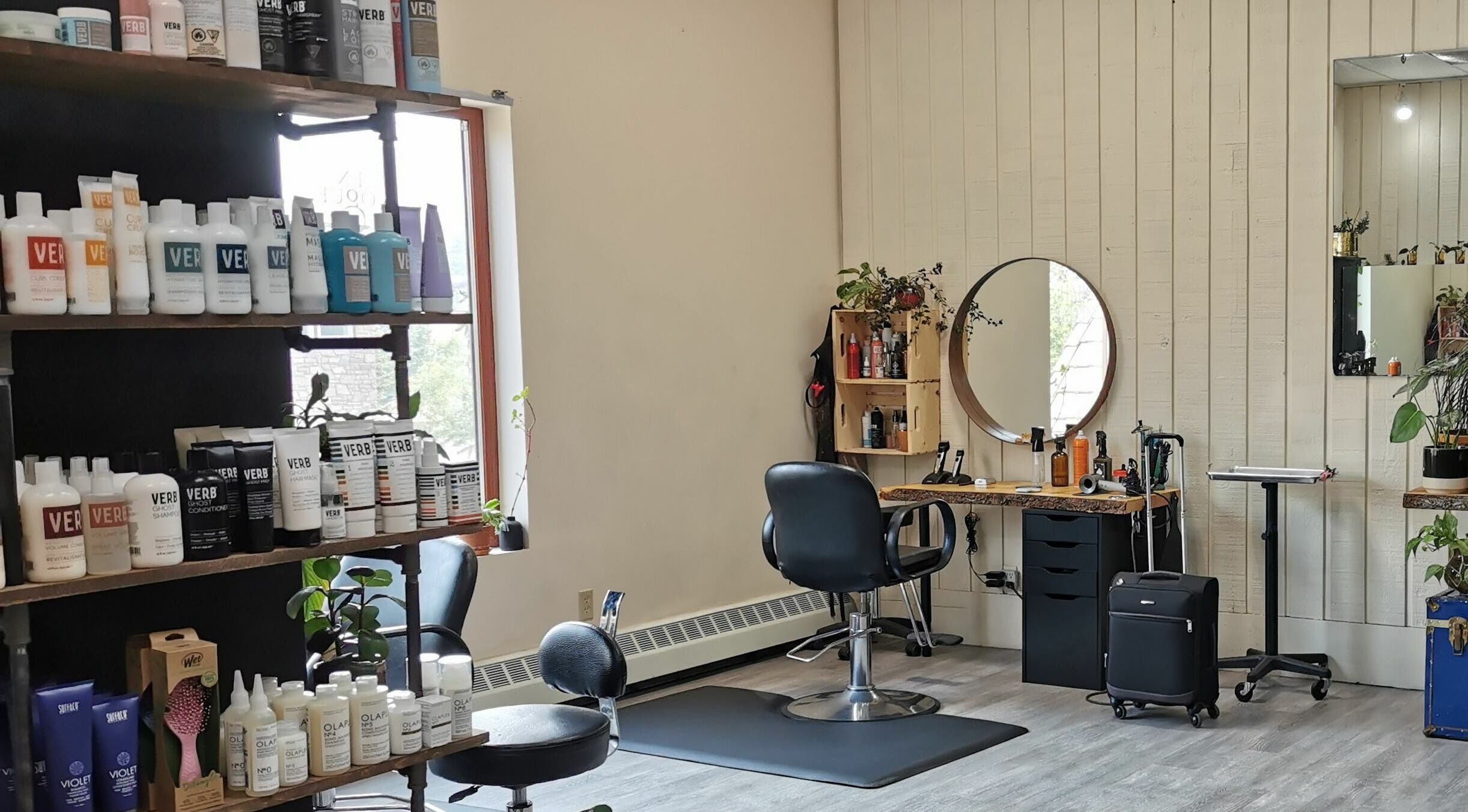 Stylish salon station at En Vogue Banff Salon, Banff, Alberta, CA, featuring beauty products and a mirror.