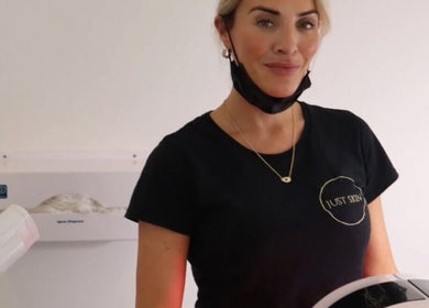 A skin specialist at Just Skin Uk, Cardiff, Wales, GB, in a treatment room, smiling warmly.