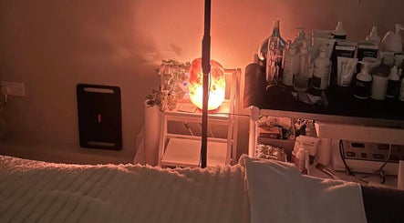 Tranquil spa setup at The Ivy Rooms in Dunmow, England with warm lighting and skincare products.