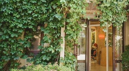 The lush entrance of Grieze, Rīga, LV, featuring green vines and an inviting doorway.