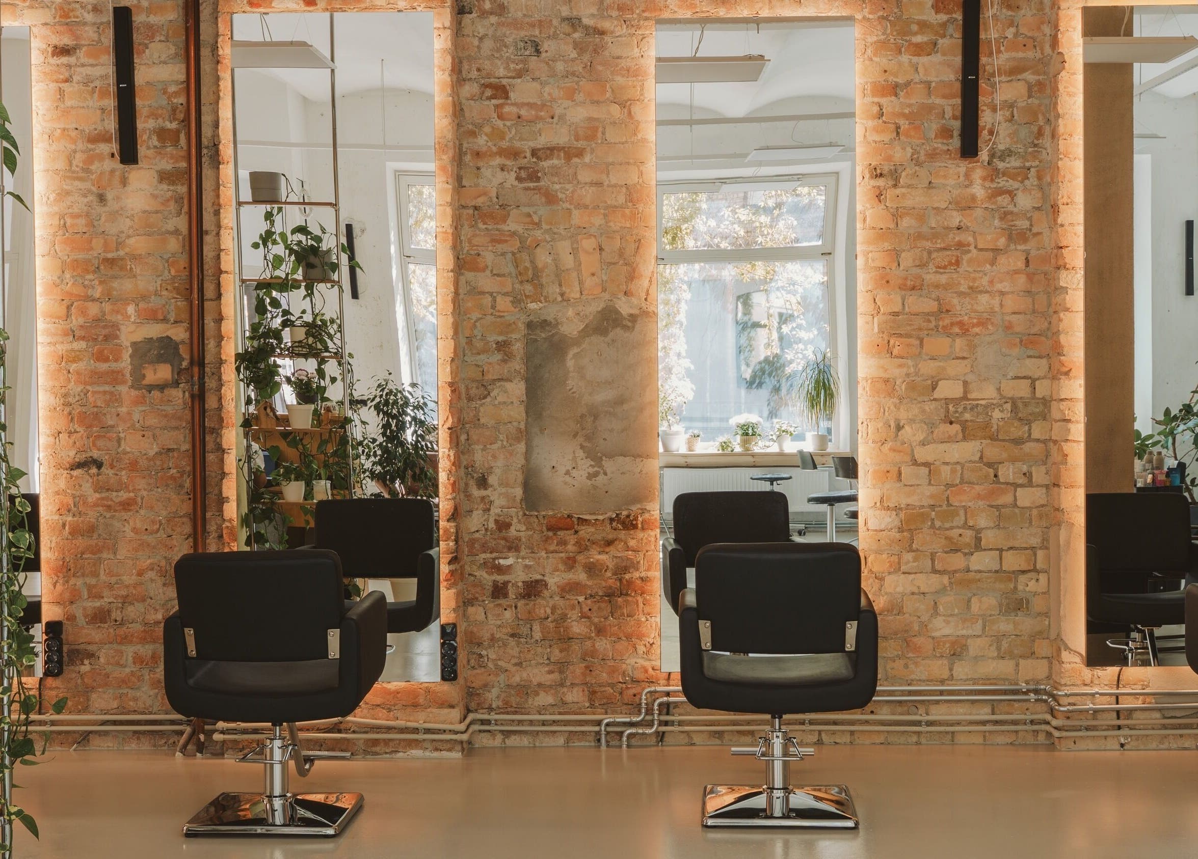 Cozy salon at Grieze, Rīga, LV, featuring modern chairs, mirrors, and lush plants.