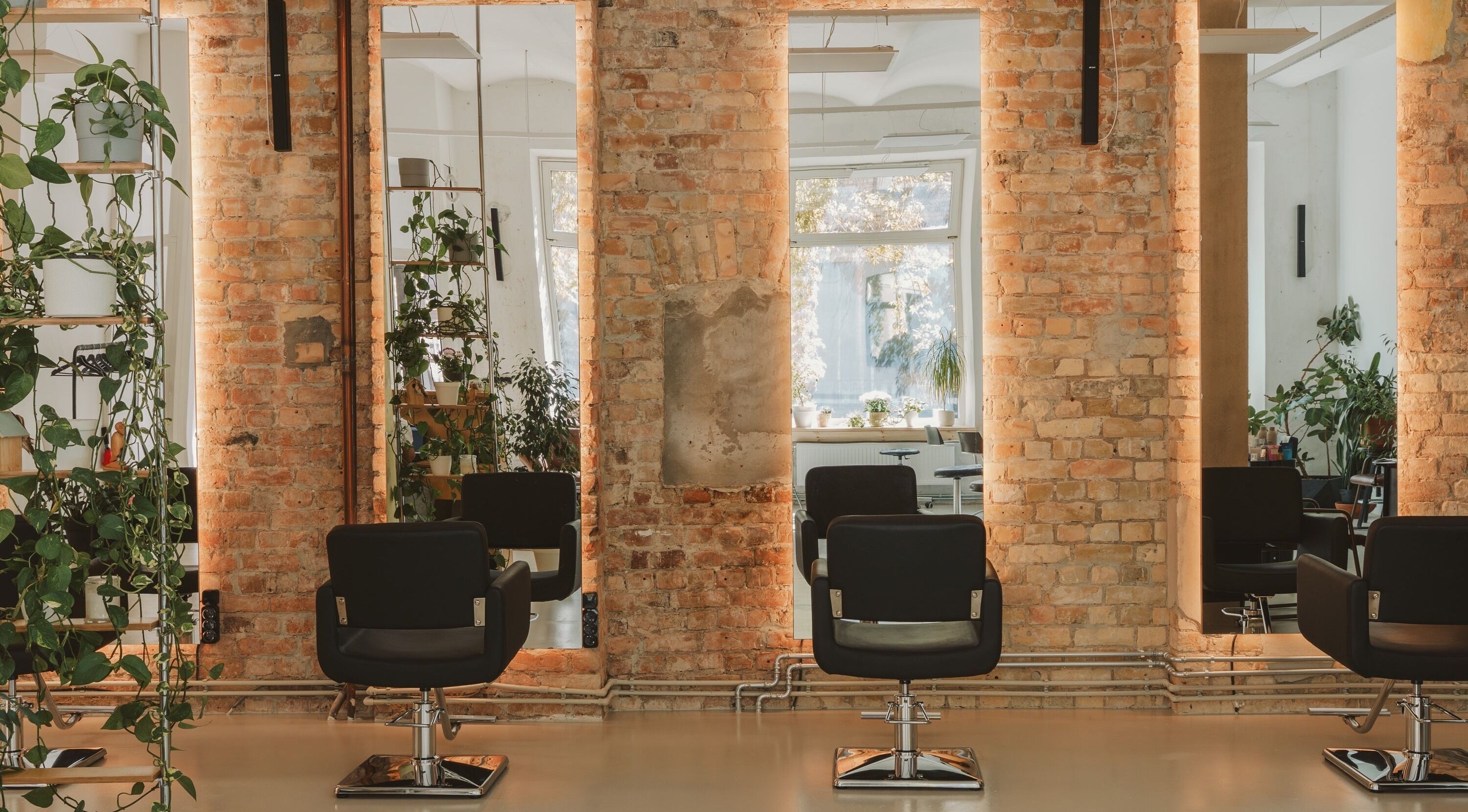 Cozy salon at Grieze, Rīga, LV, featuring modern chairs, mirrors, and lush plants.