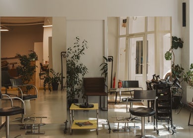 Modern salon interior at Grieze, Rīga, LV, with stylish chairs, mirrors, and greenery.